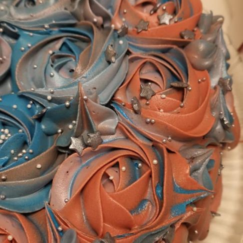En kake med blå og rosa glasur blomster dekor som dekker hele kaken