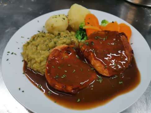 Fiskekaker i brunsaus på en tallerken med gulrot, brokkoli, potet og ertestuing