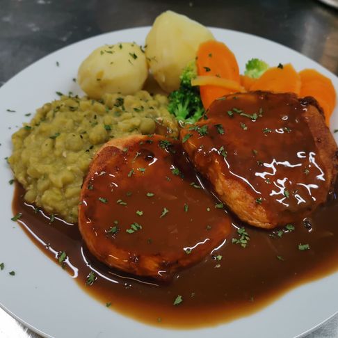 Fiskekaker i brunsaus på en tallerken med gulrot, brokkoli, potet og ertestuing